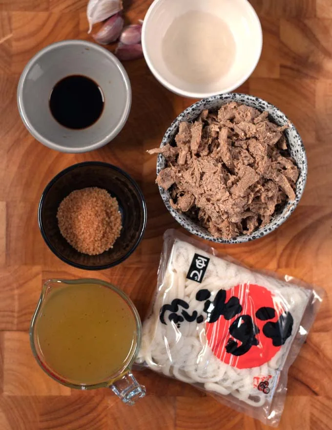 Ingredients needed to make Beef Udon collected on a board.