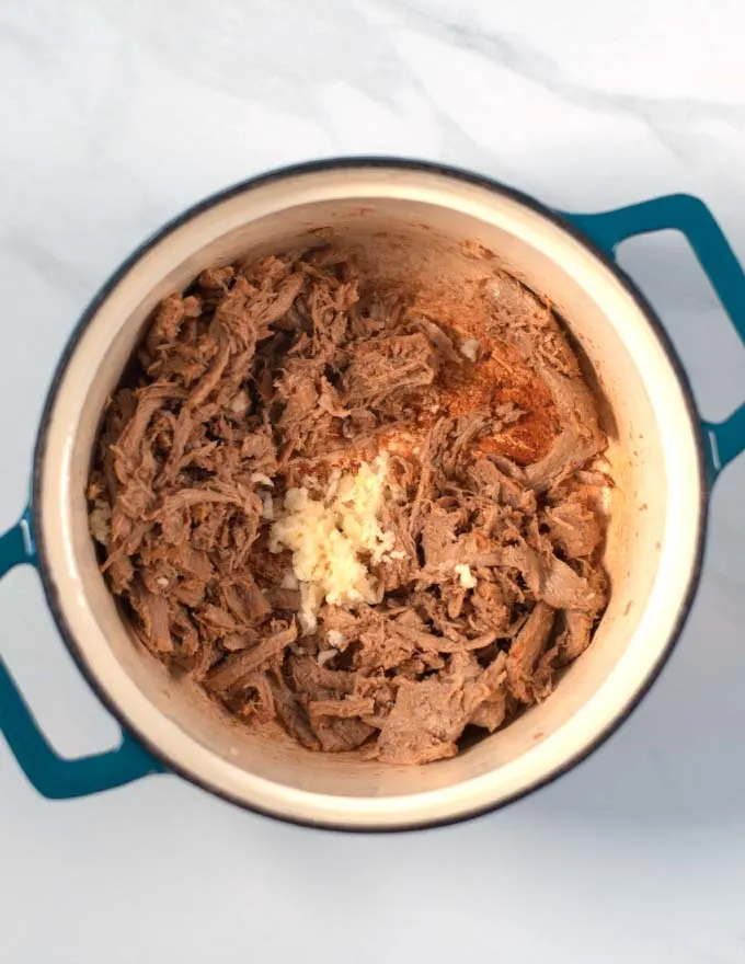 Vegan beef and garlic are fried in a pot.