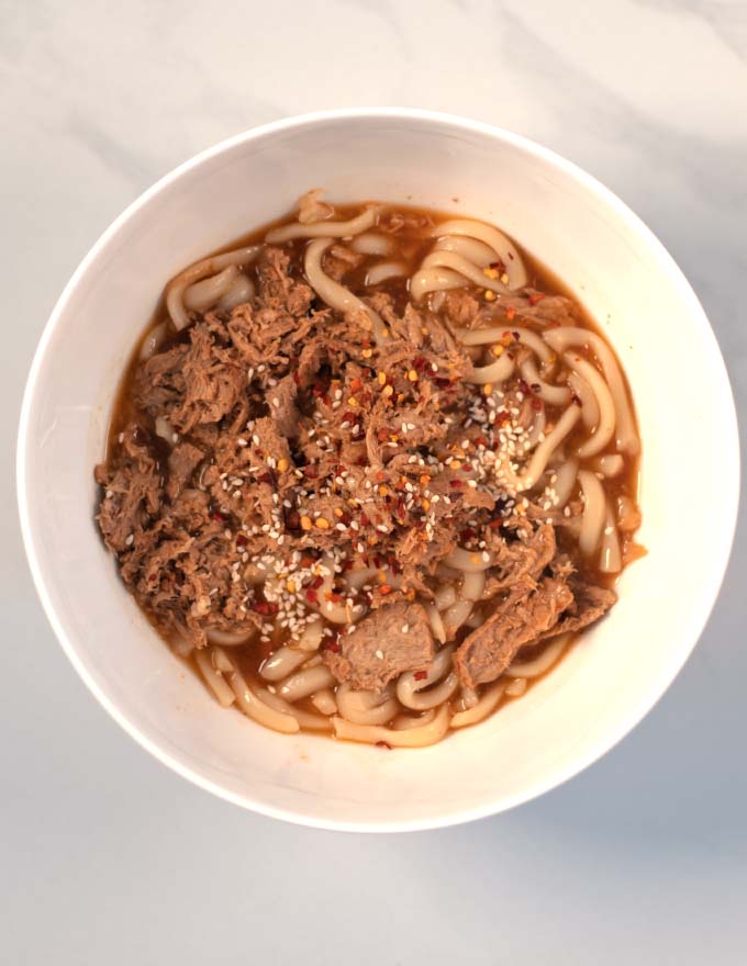 Sesame seeds and chili flakes are used to harnish Beef Udon Noodles.