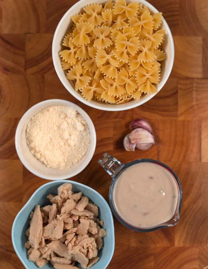 Ingredients needed to make Cream of Chicken with Pasta are collected on a board.