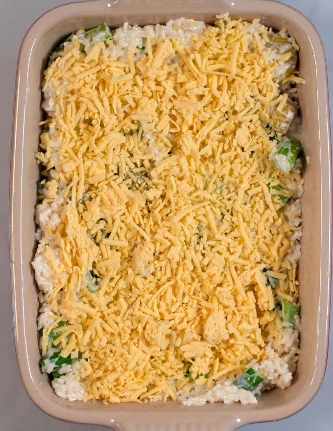 Vegan cheese tops the Chile Rice Casserole in a baking dish before baking.