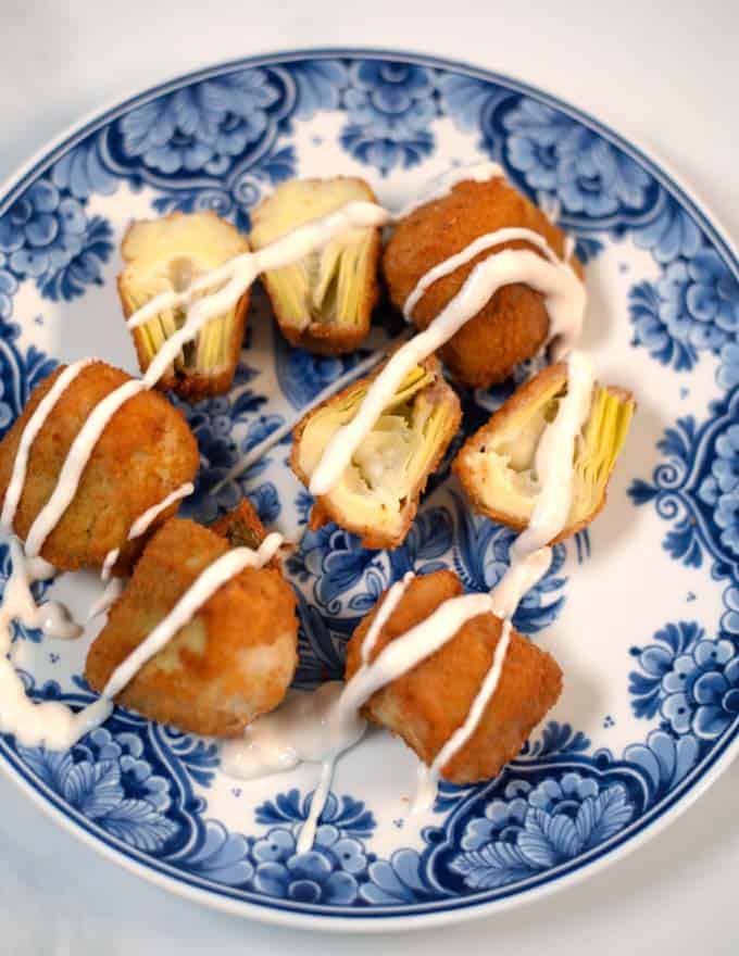 A plate of fried artichoke hearts sprinkled with sauce.