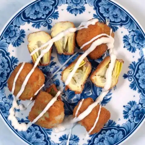 A serving of Fried Artichoke Hearts with sauce.