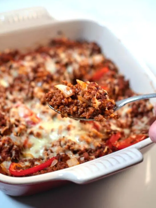 A spponful of Keto Sloppy Joe Casserole is lifted from the baking dish.
