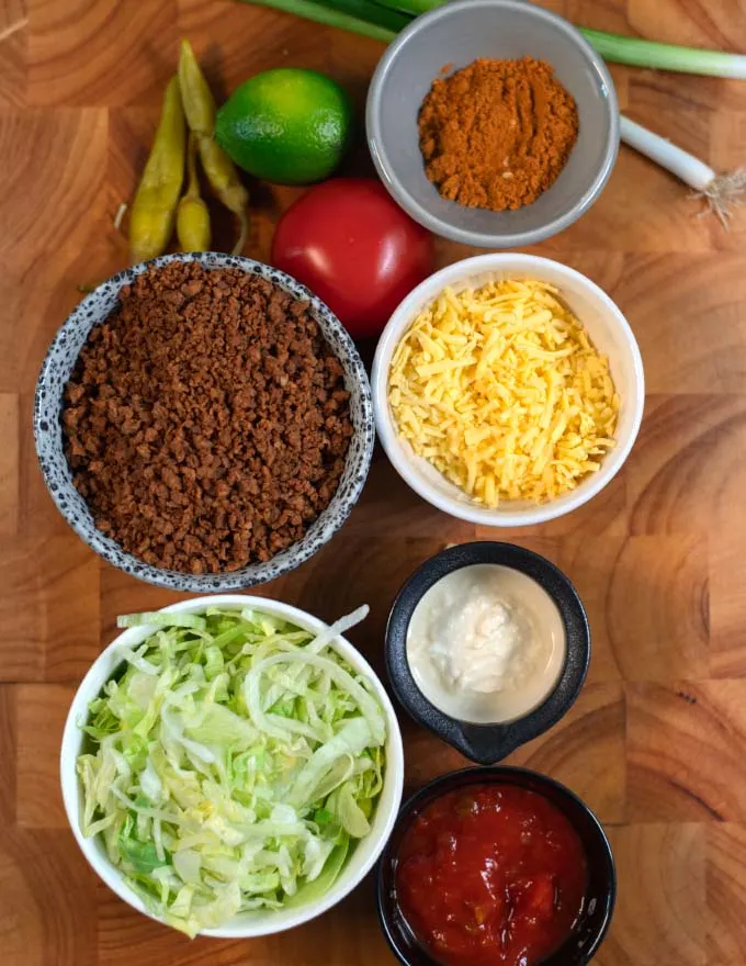 Ingredients needed to make Keto Taco Salad collected on a board.