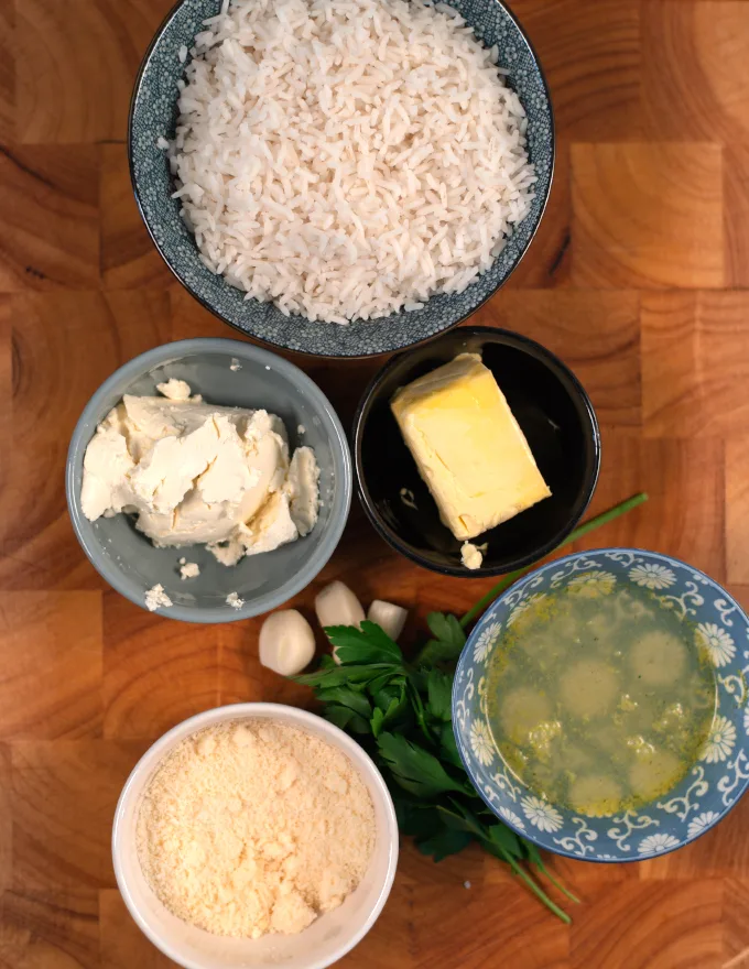 Ingredients needed to make Parmesan Rice collected on a board.