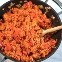 A wooden spoon in Smoked Sausage and Rice.