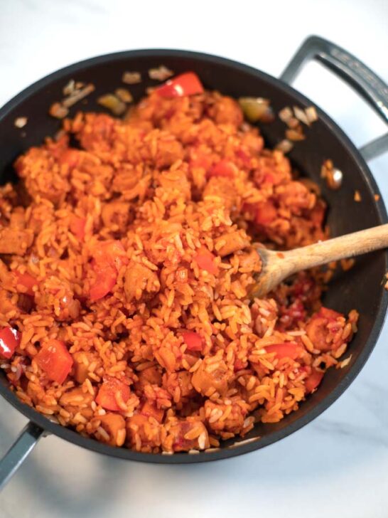 A wooden spoon in Smoked Sausage and Rice.