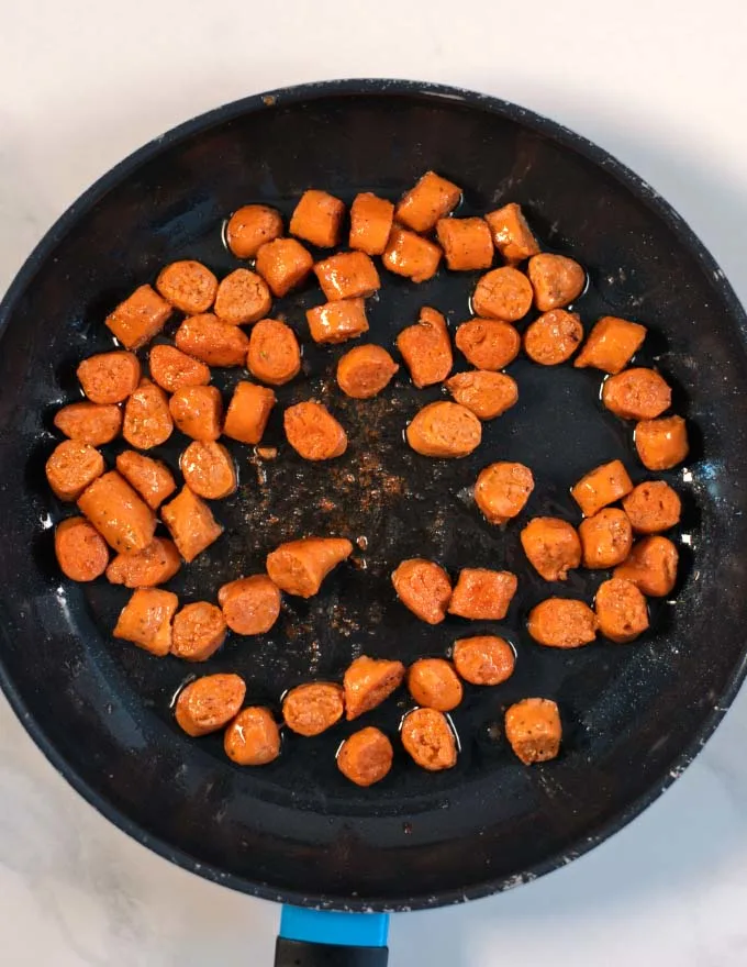 Sausage bits are browned in a pan.