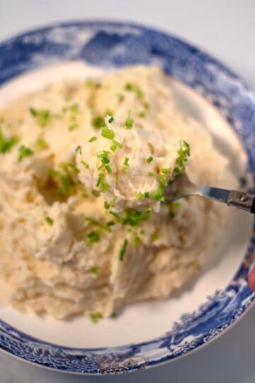 A spoon full of Mashed Potatoes and Cauliflower is lifted.