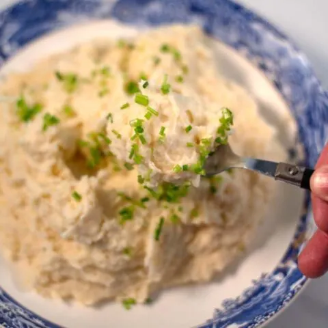 A spoon full of Mashed Potatoes and Cauliflower is lifted.