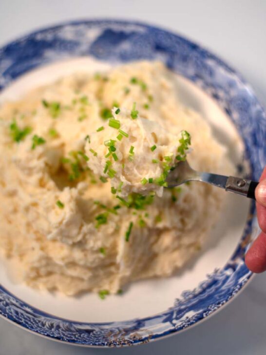 A spoon full of Mashed Potatoes and Cauliflower is lifted.