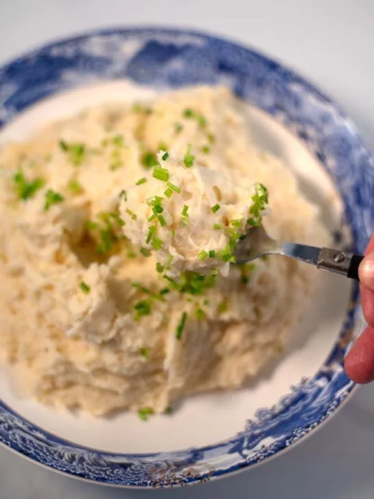 A spoon full of Mashed Potatoes and Cauliflower is lifted.
