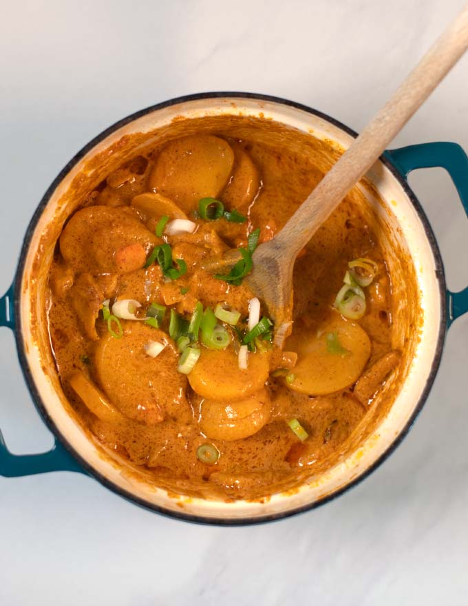 The ready Vietnamese Curry in a pot with a wooden spoon.