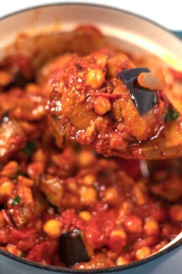 A wooden spoon lifts Lebanese Moussaka from the pot.