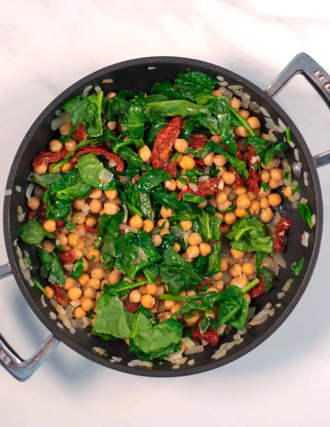 Basil and baby spinach are added to the pan.