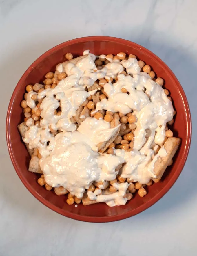Yogurt sauce is sprinkeled generously over the chickpeas.