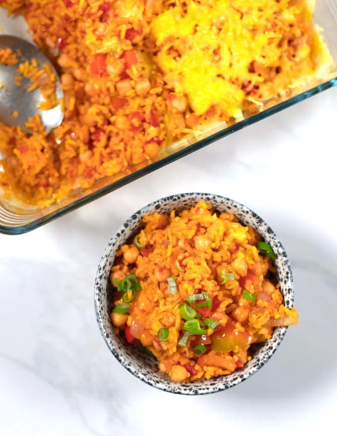 A serving of Leftover Spanish Rice Bake with the baking dish in the background.