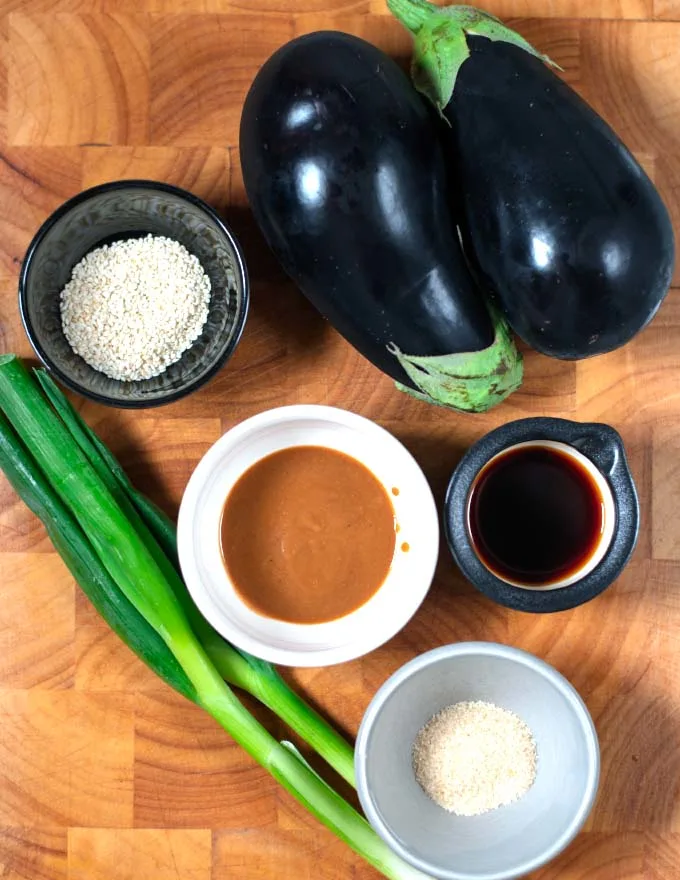 Ingredients needed to make Miso Eggplant on a wooden board.