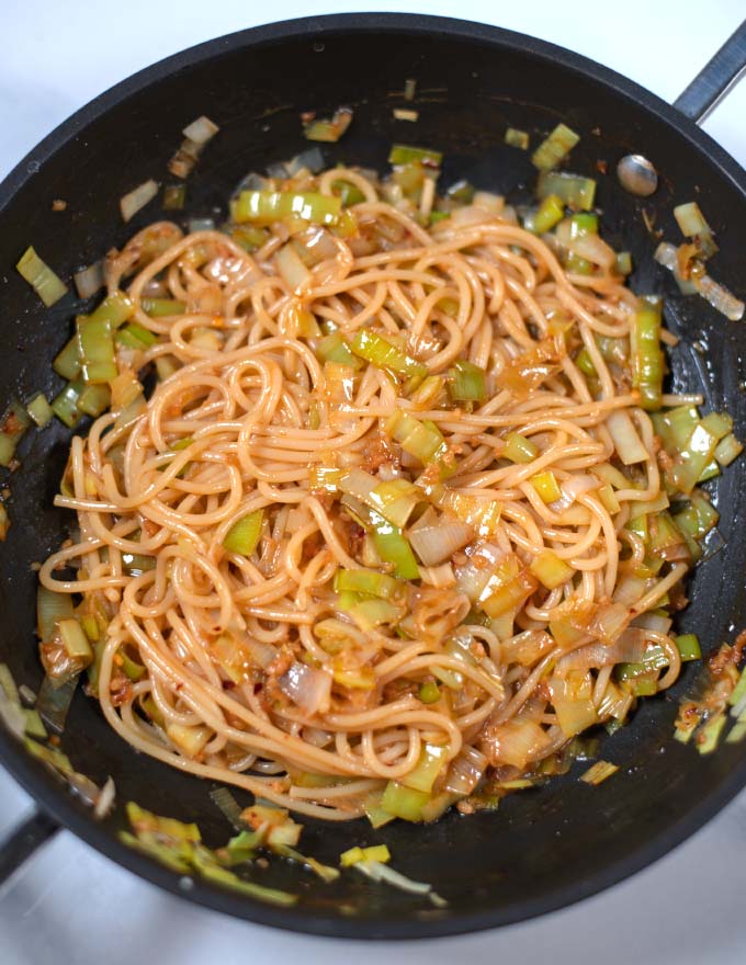 Close-up of Miso Pasta made with leek in a frying pan.
