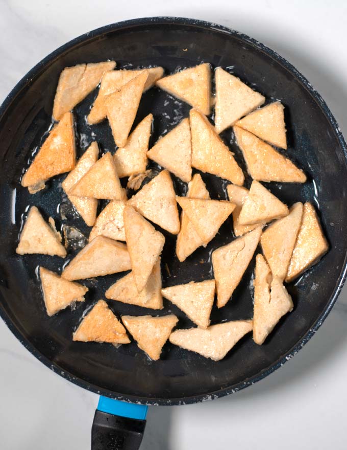 Cornstarch covered tofy bites in a pan.