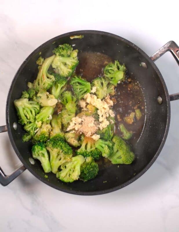 Seasonings and liquid ingredients are added to the broccoli.