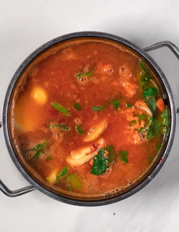 Adding vegetable broth to the Turkish Lentil Soup.