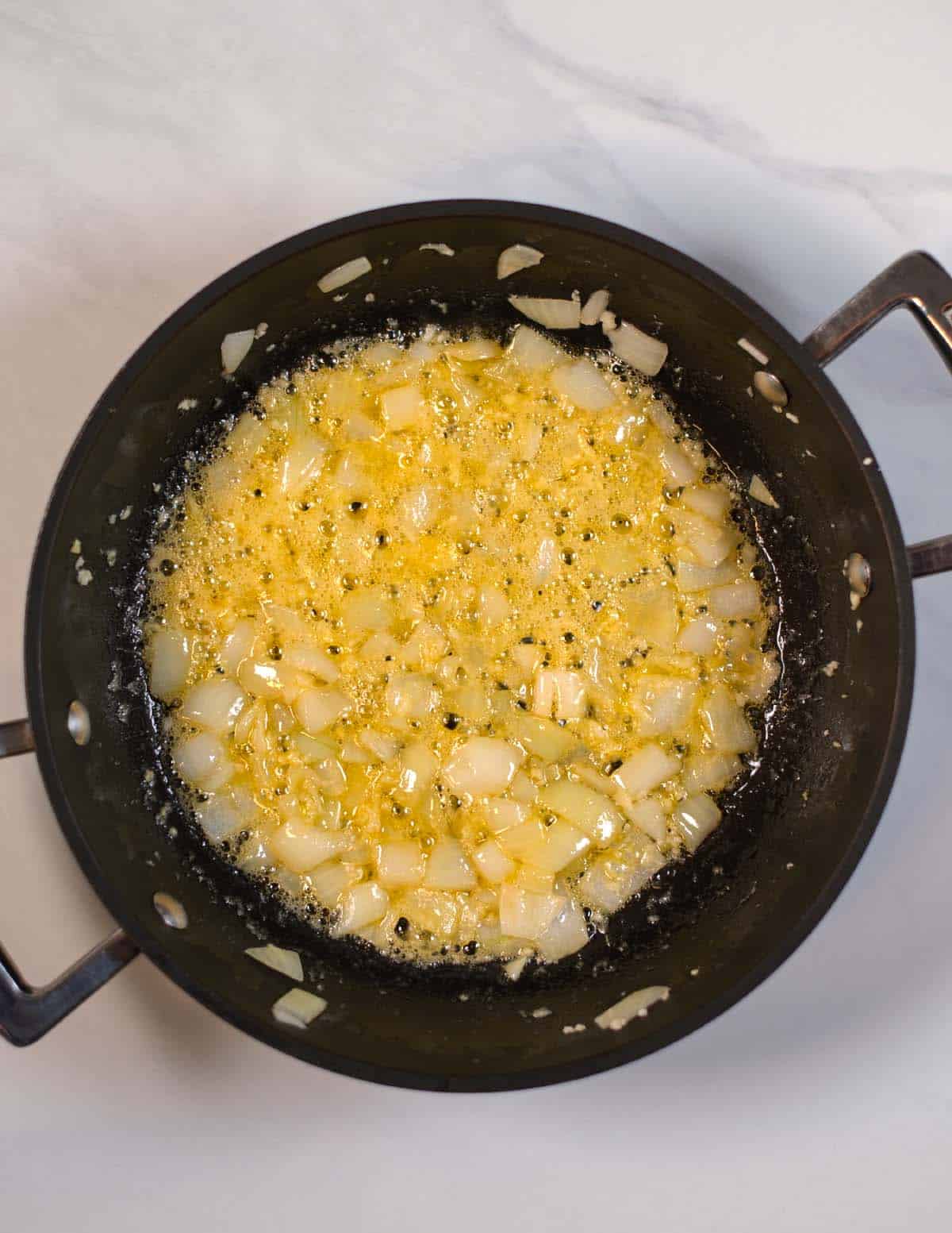 Onions are sauteed in butter in a medium size pan.