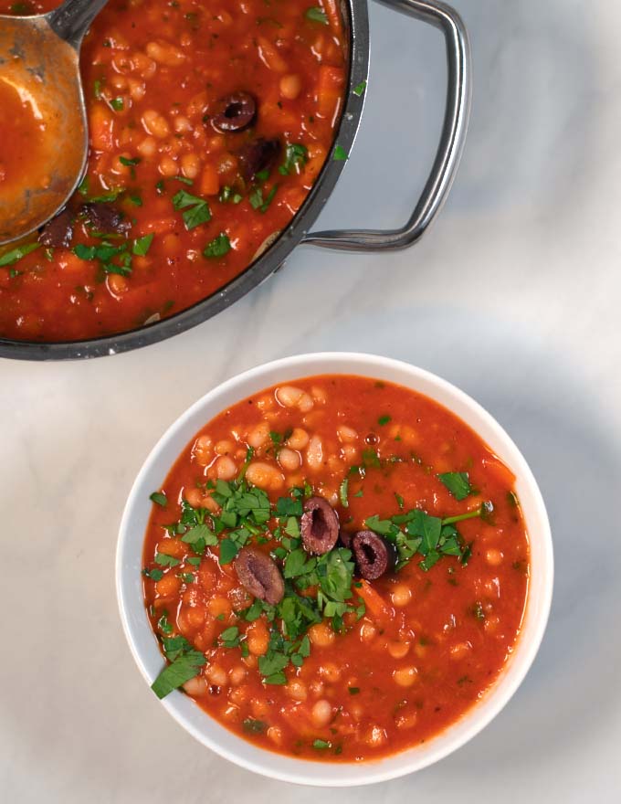 A serving of Fasolada in a small white bowl.