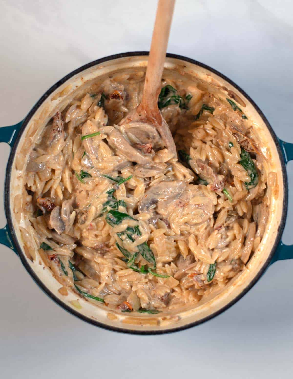 The precooked orzo is added to the creamy sauce.