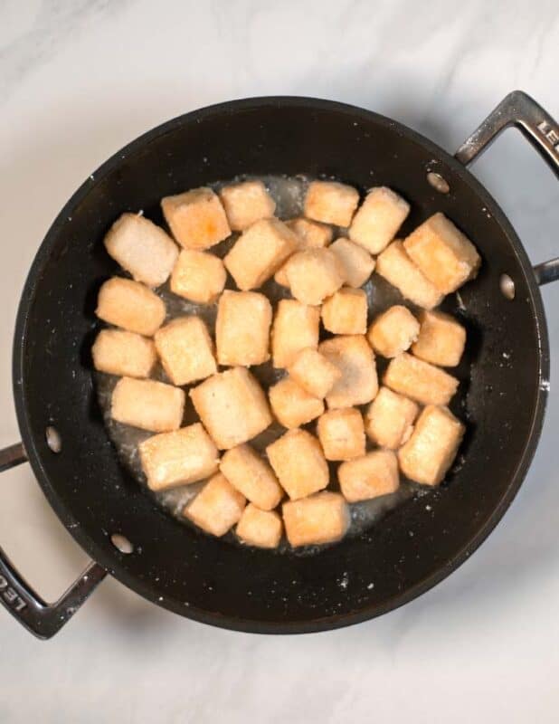 Cornstarch coated tofu cubes are crispy fried.