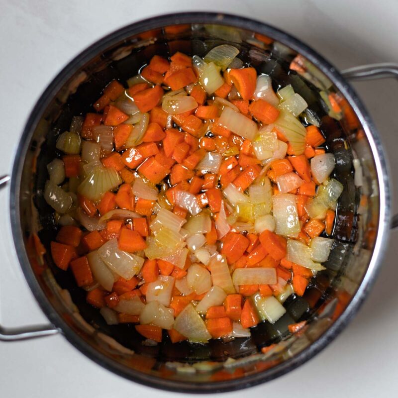 Diced onions and carrots are sauteed in olive oil.