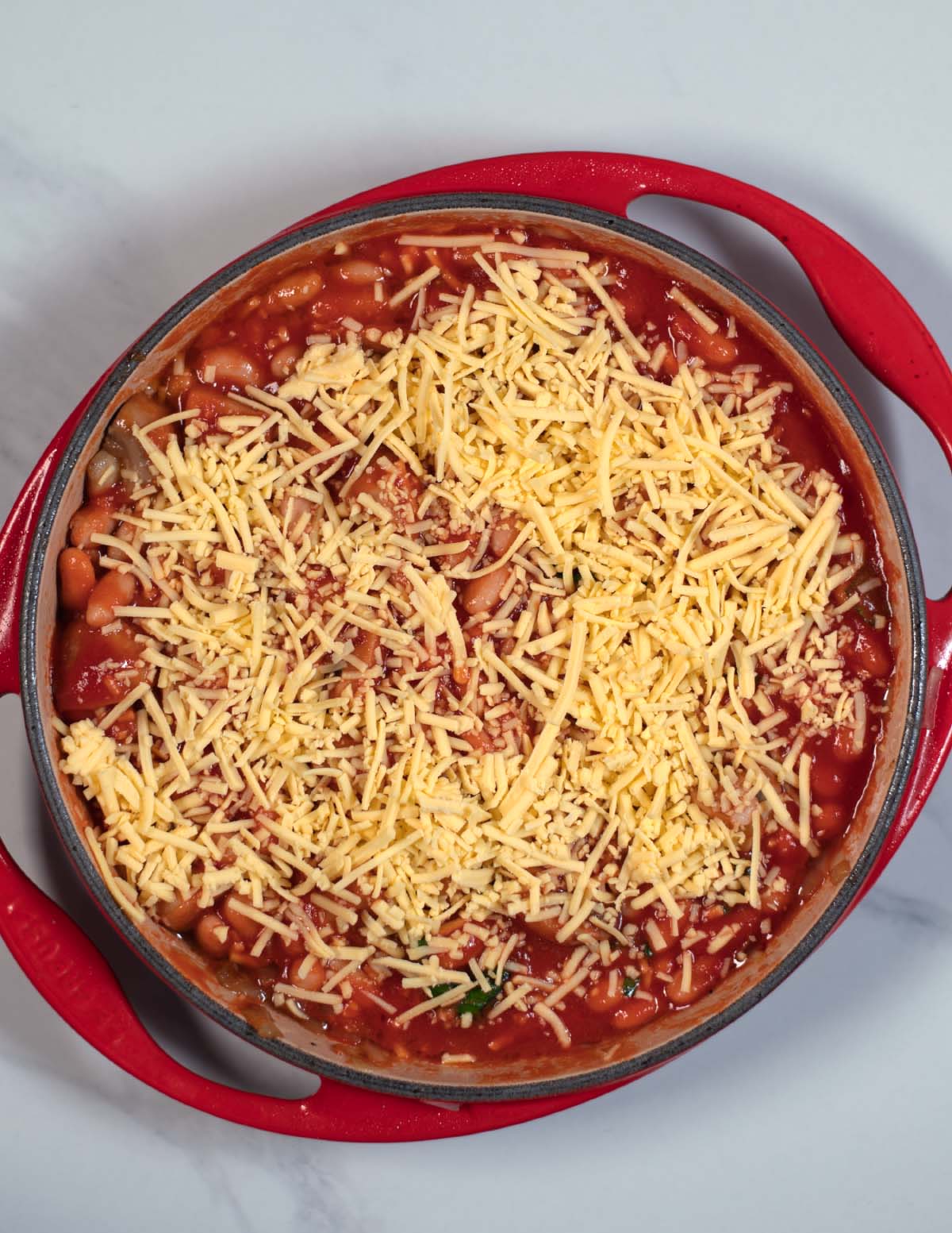 Vegan cheese is added on top of the beans.