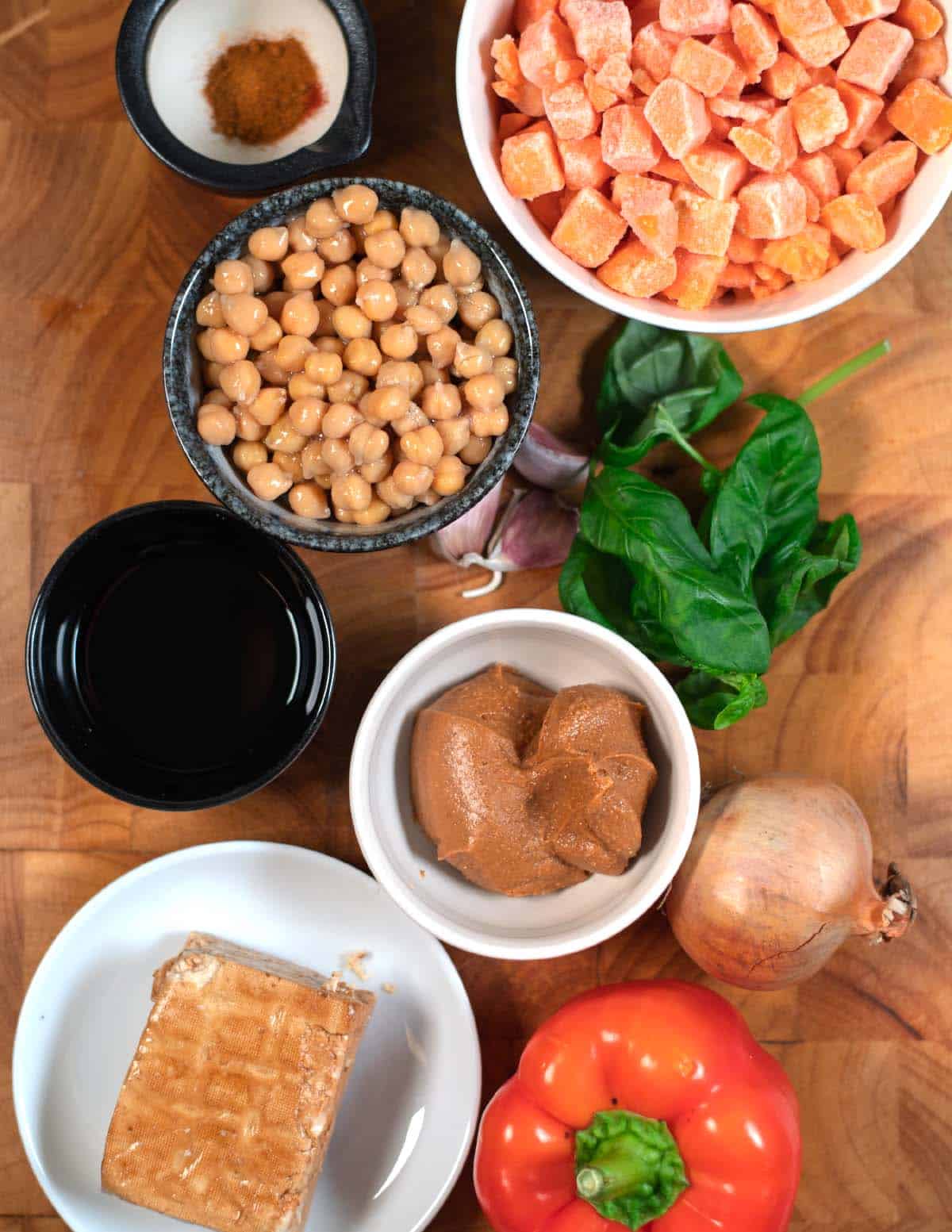 Ingredients needed to make Sweet Potato Salad collected before preparation on a wooden board.