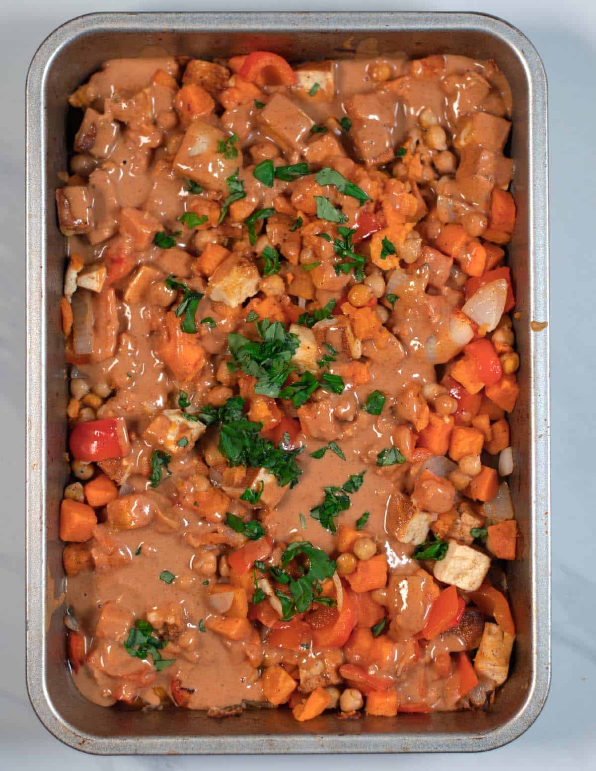Creamy peanut dressing and fresh basil is given over the roasted vegetables.