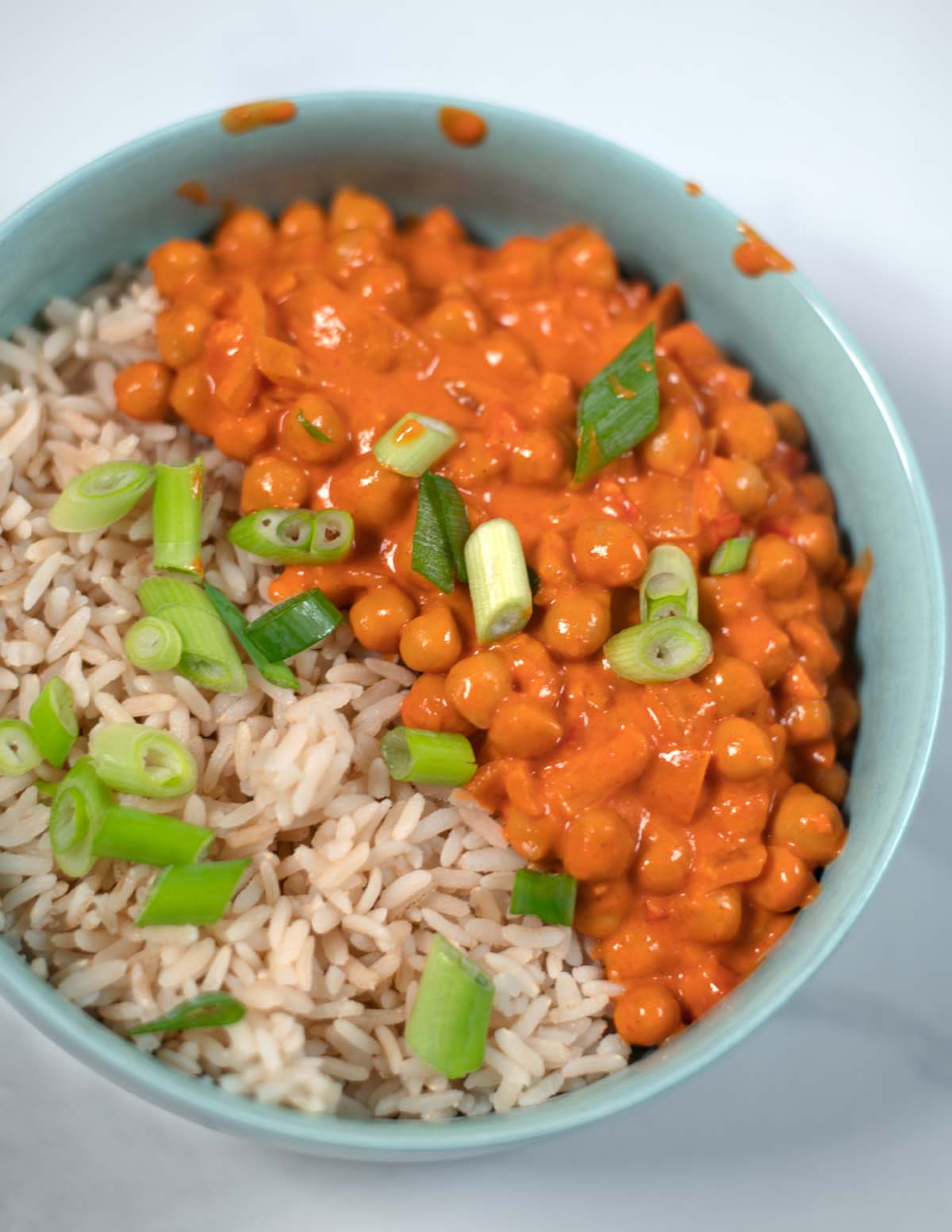 Closeup of Butter Chickpeas served with fresh scallions.