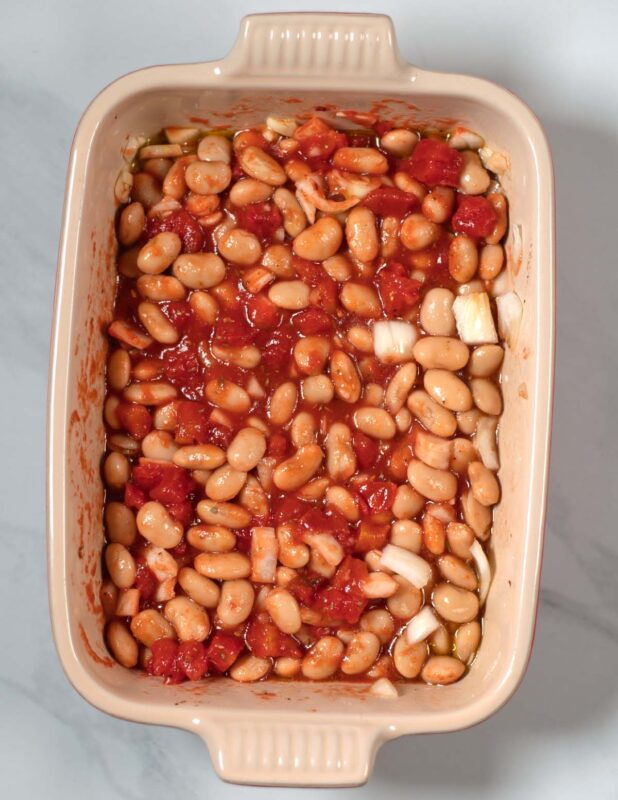 Gigantes Plaki in a baking dish before baking in the oven.