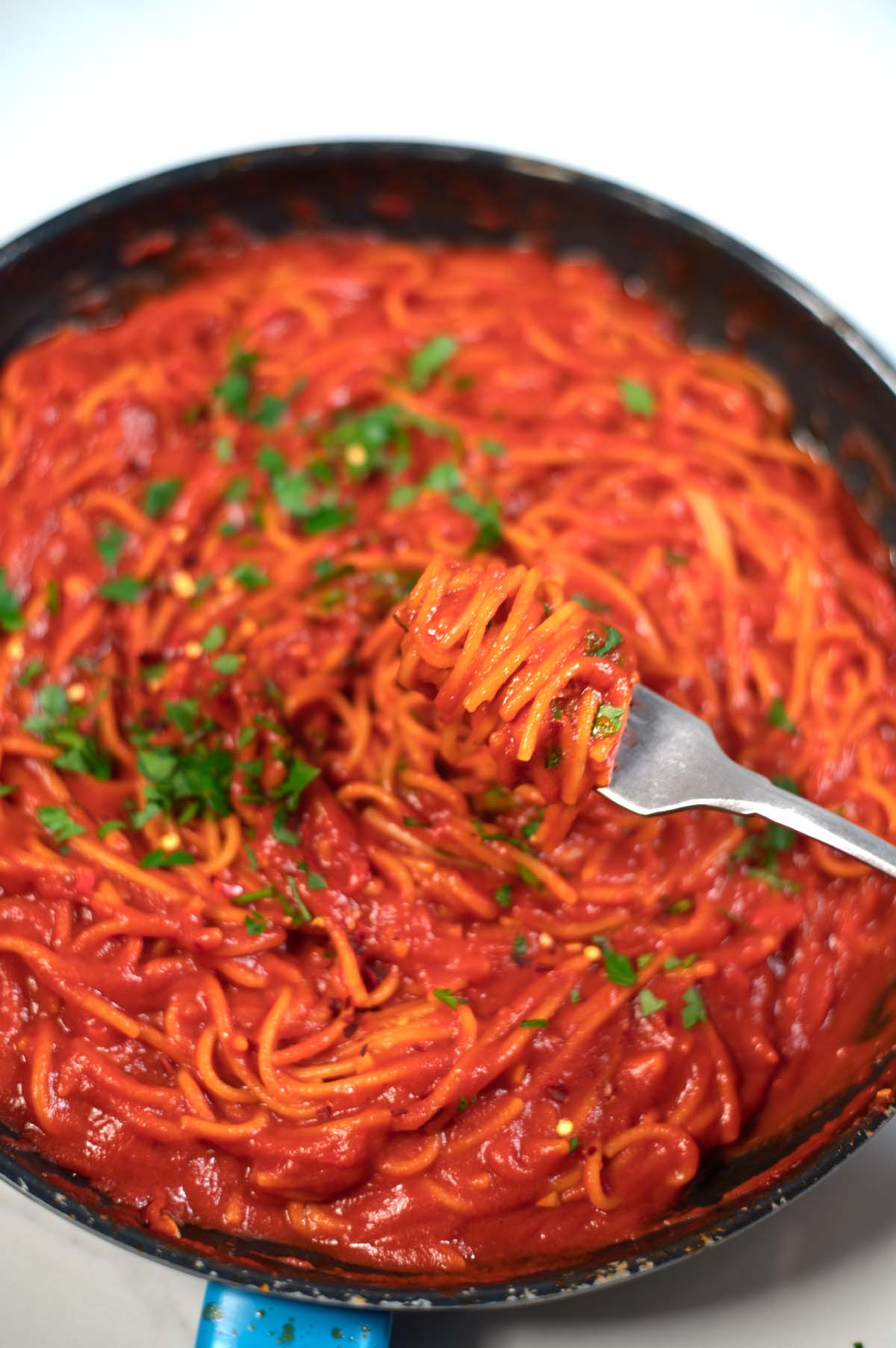 View of the pan in which Spaghetti All'Assassina have been cooked, with a fork.