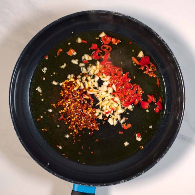 Garlic, chili flakes, red pepper are fried in hot olive oil.