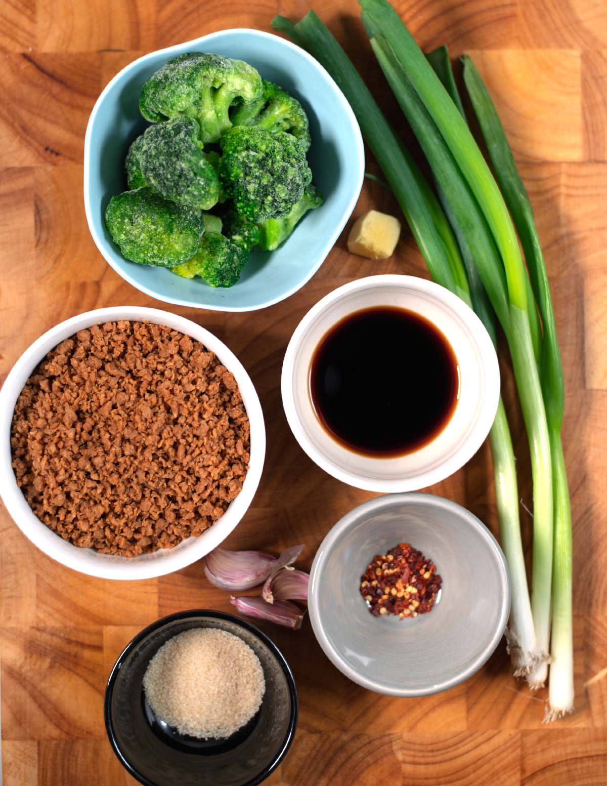 Ingredients needed to make Teriyaki Bowl collected on a wooden cutting board.