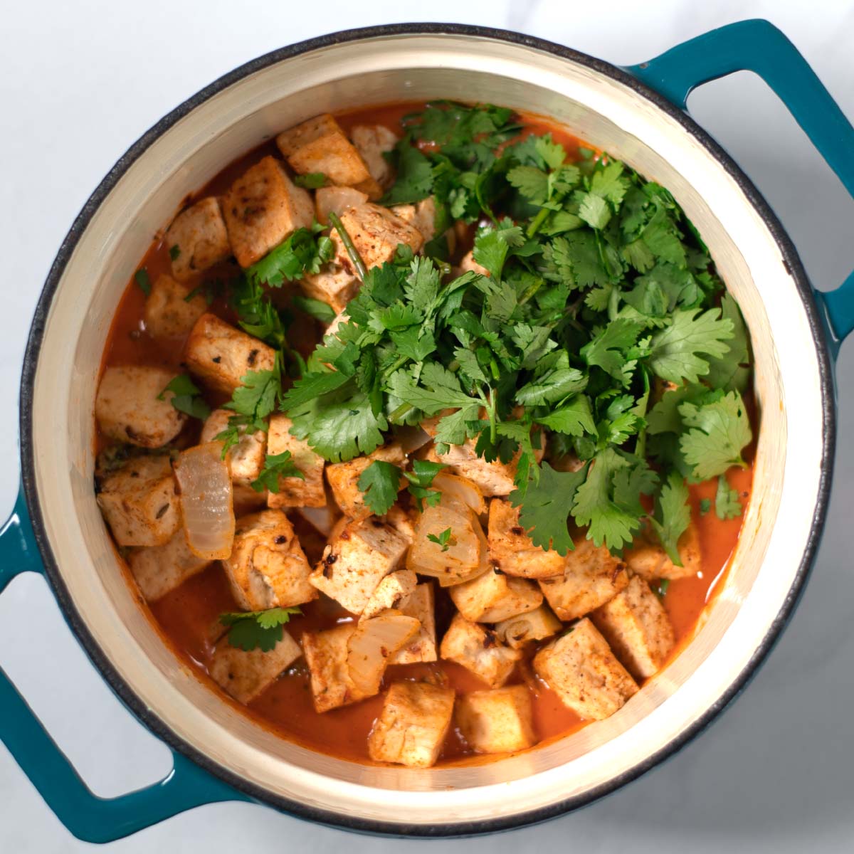 Tofu cubes are given into the pot with the sauce.