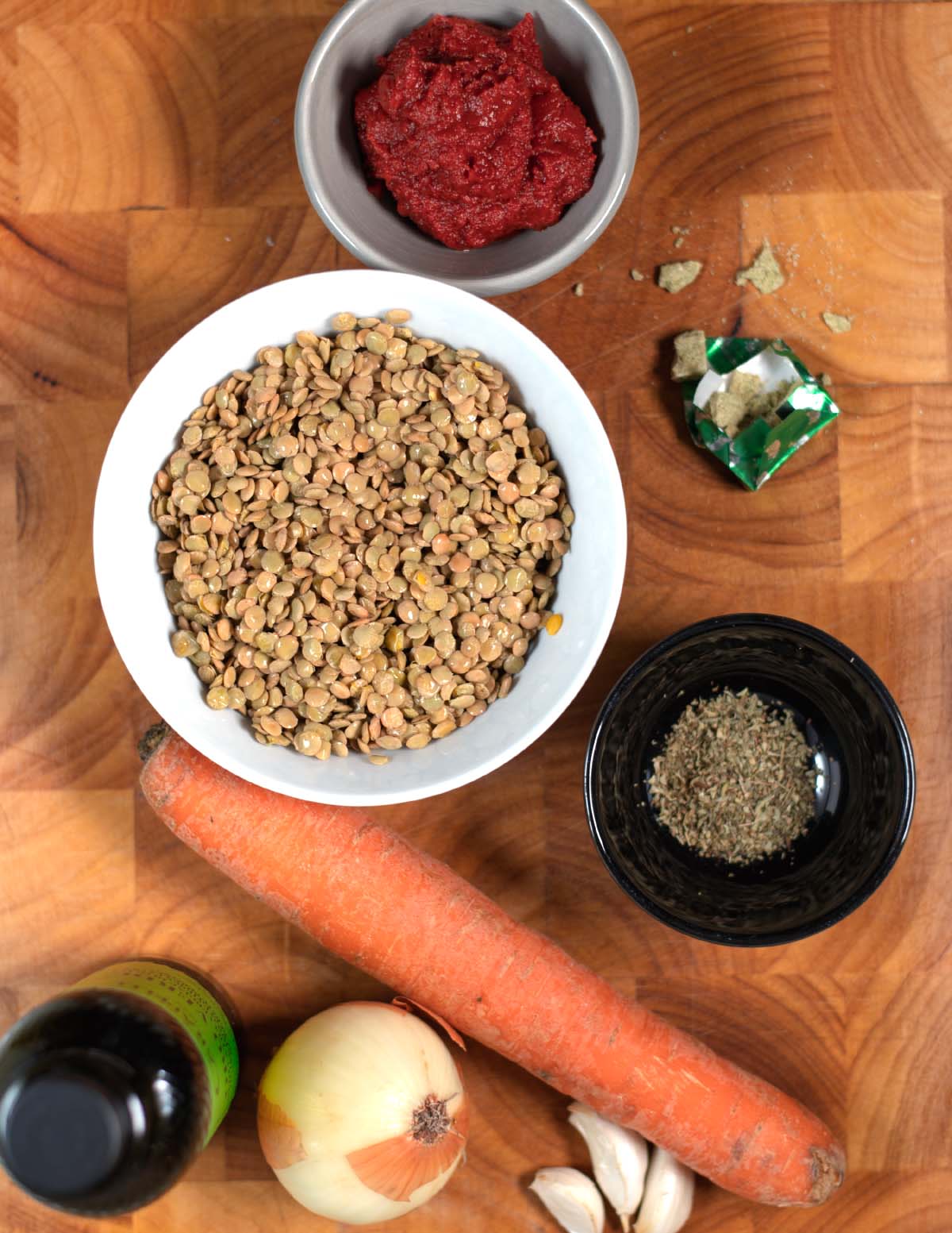 Ingredients needed to make Greek Lentil Soup are collected on a board before preparation.