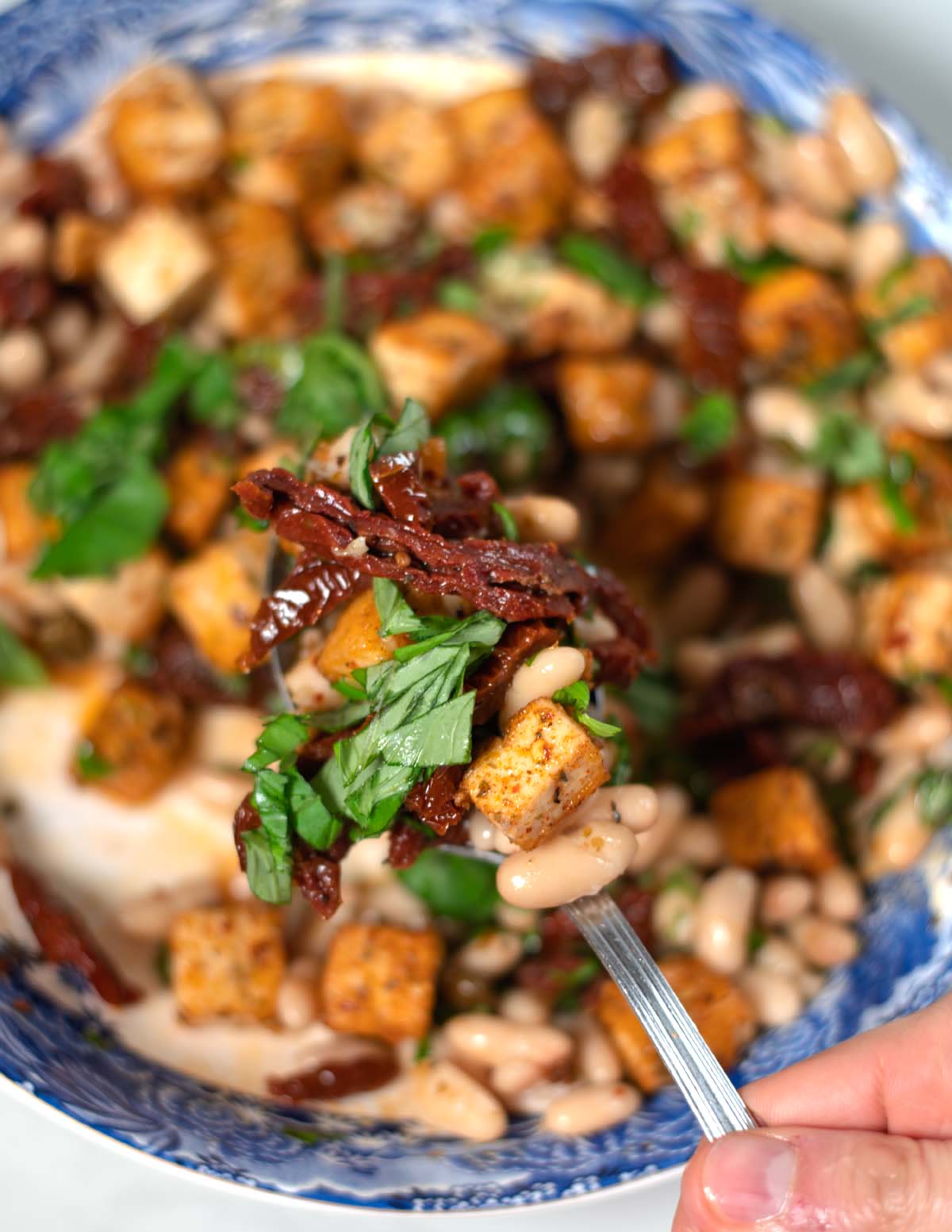 A spoonful of Marry Me Salad is lifted from the serving bowl.