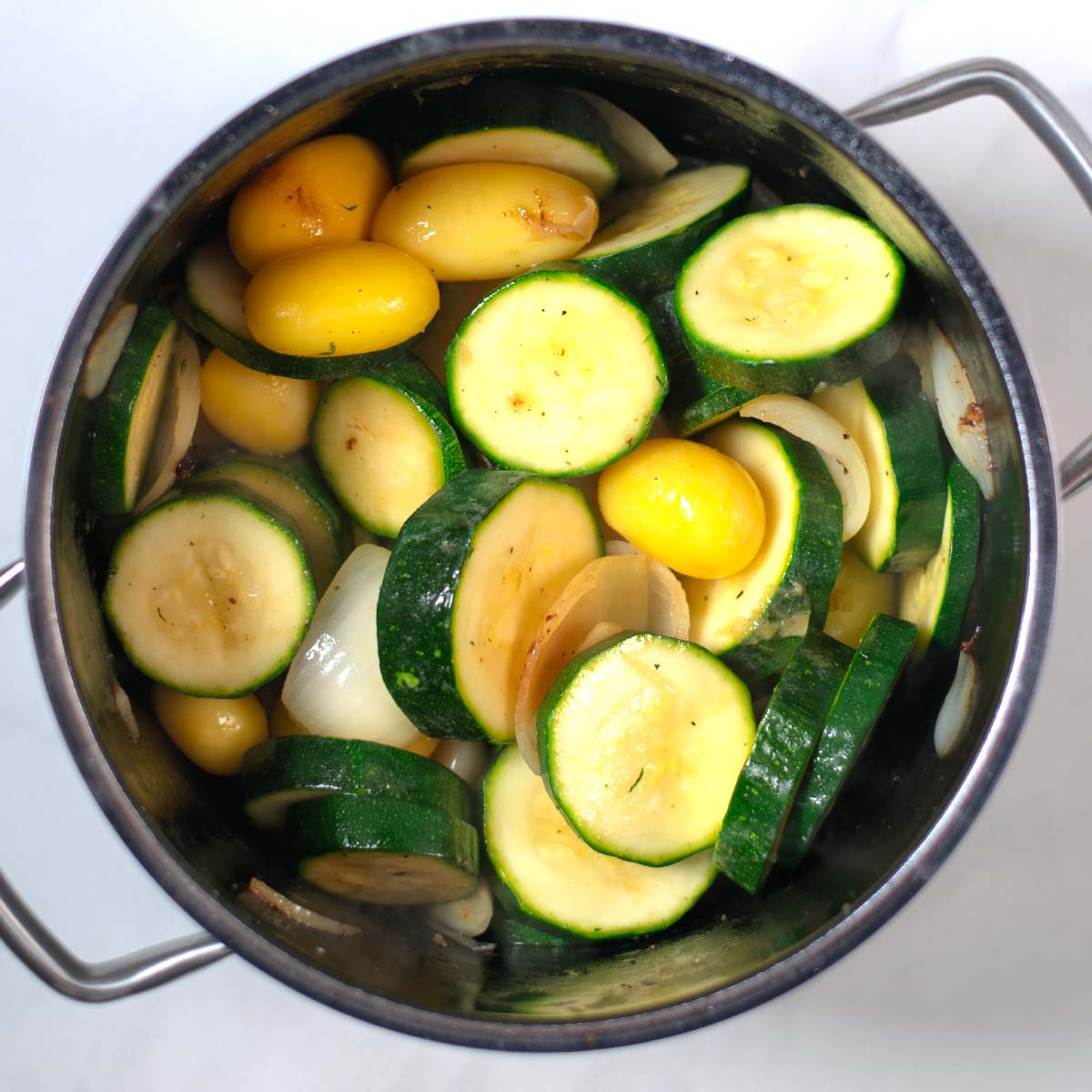 Zucchini and onions browned in a pot.