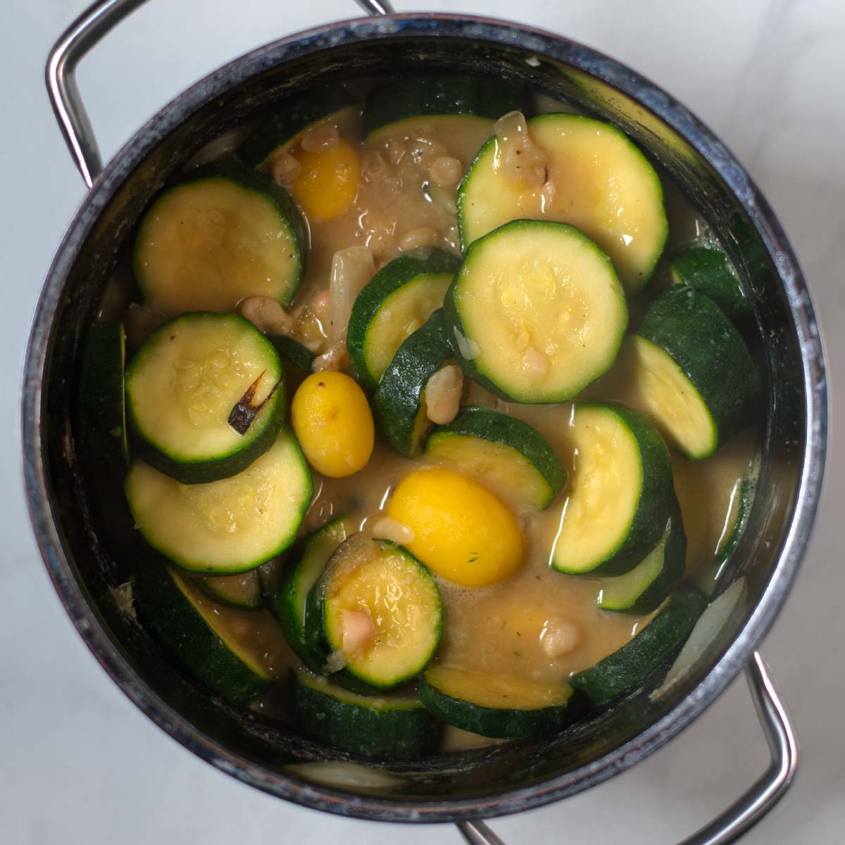 Vegetable broth is added to the soup pot.