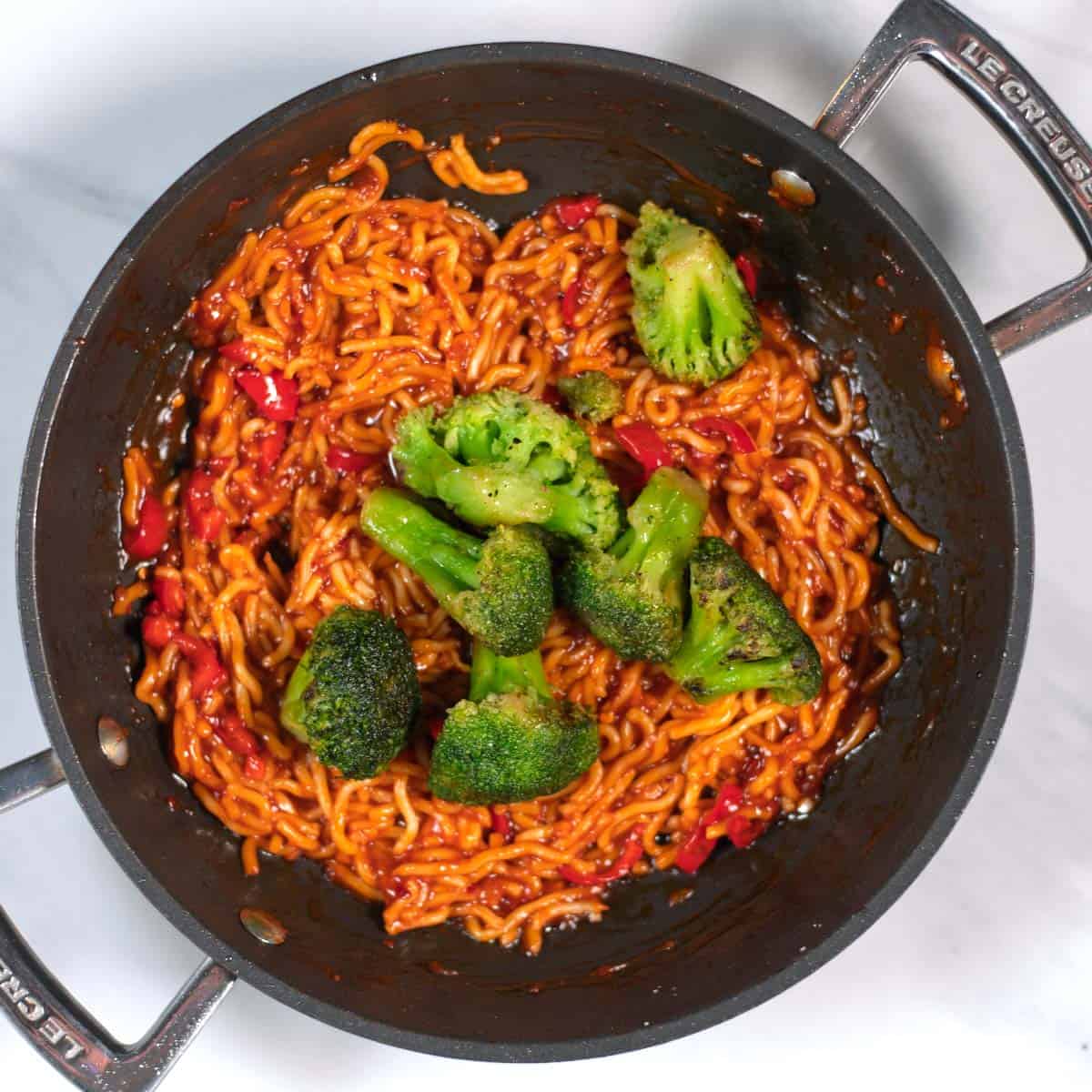 Pre-roasted broccoli is given onto the Chili Noodles.