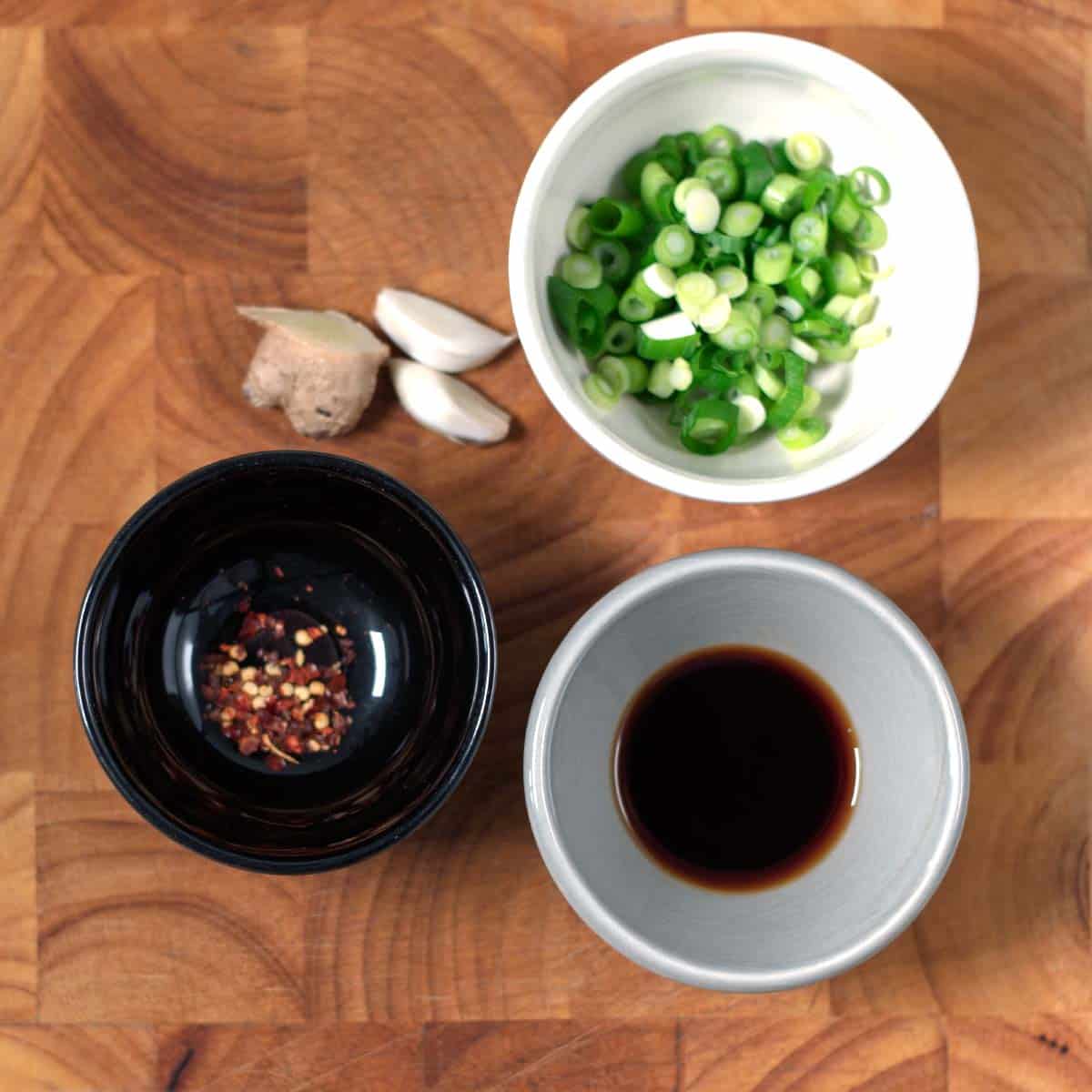 Ingredients needed to make Gyoza Sauce collected on a wooden board.
