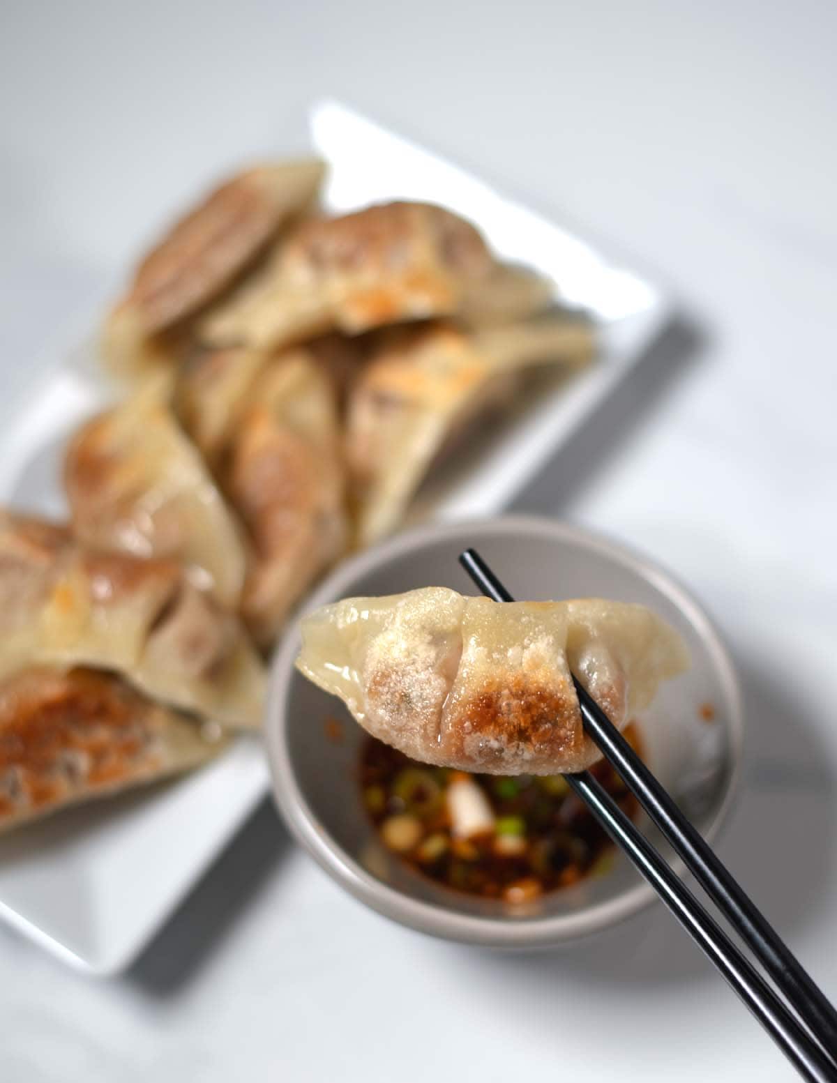 Chopsticks hold one dumpling.