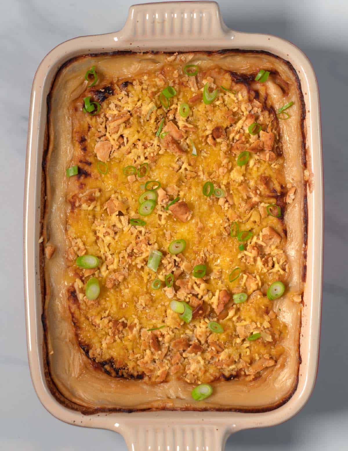 Top view of the golden baked Million Dollar Potatoes with green onion garnish.