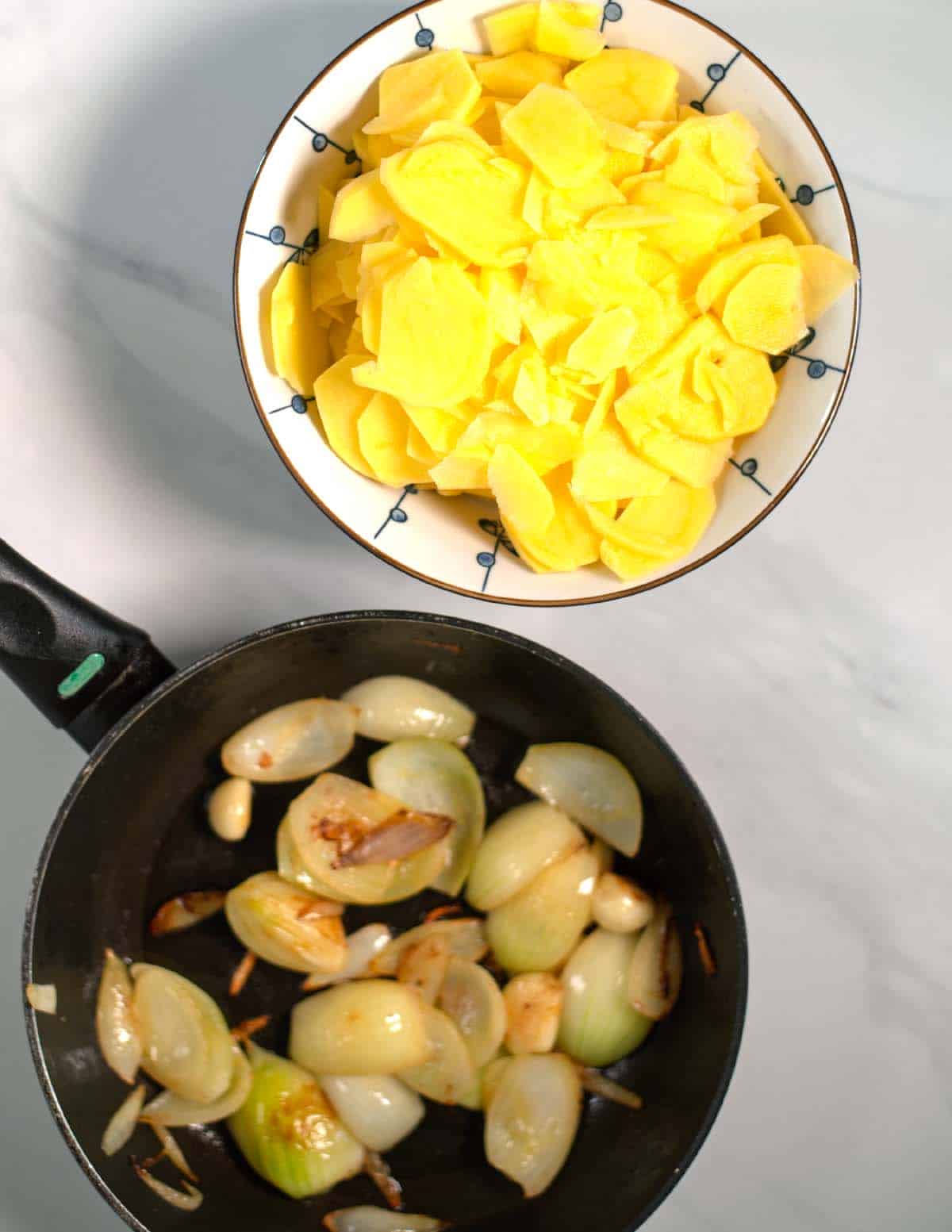 Sliced potatoes and sautéed onions for creamy baked potato casserole.